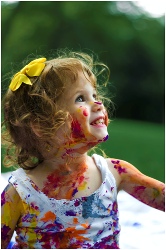 A little girl enjoying painting.
